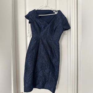Kay Unger knee length sheath dress with asymmetrical neckline. Navy blue color